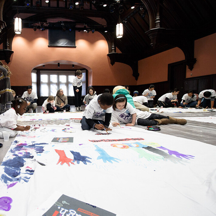 children on the floor painting murals